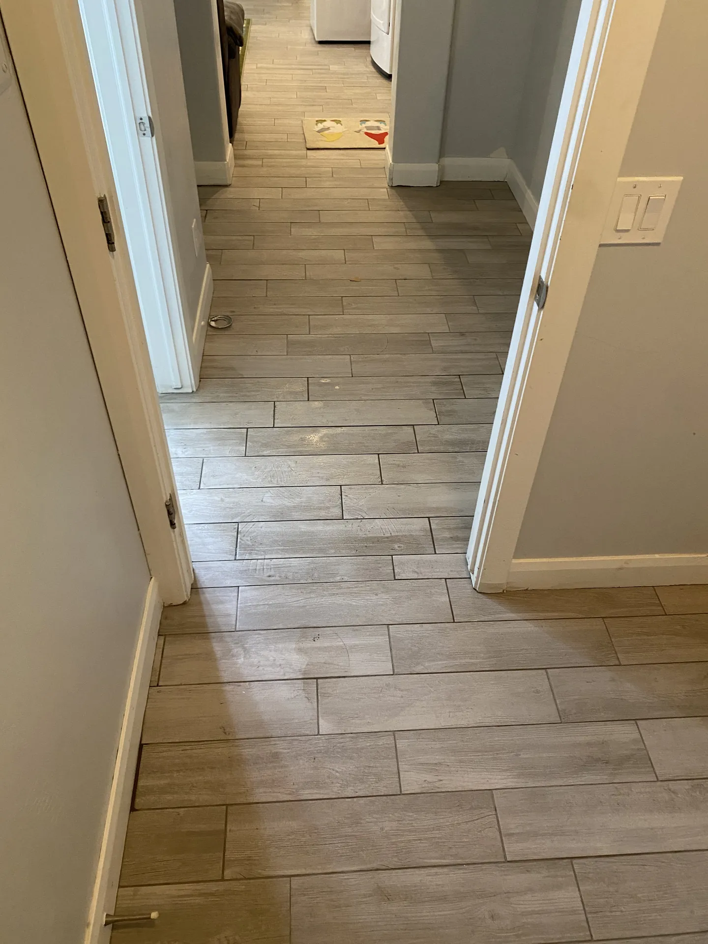 Finished wood-look plank tile running through hallway and laundry room — St. George, Utah