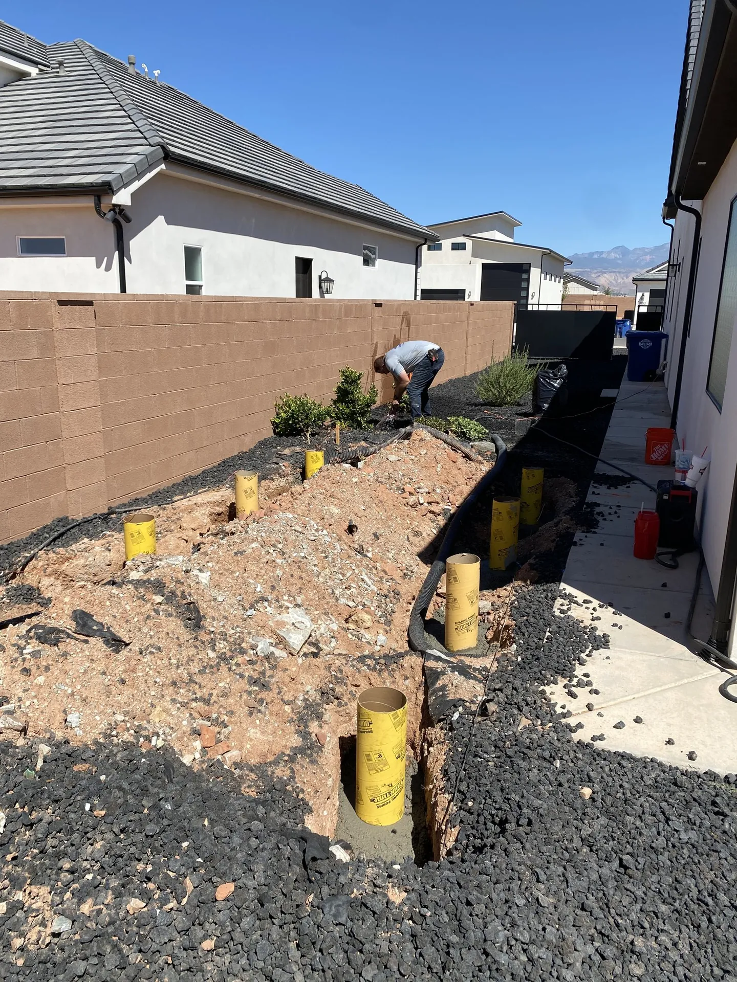 Concrete pier footing forms set in the excavated ground before the floor framing