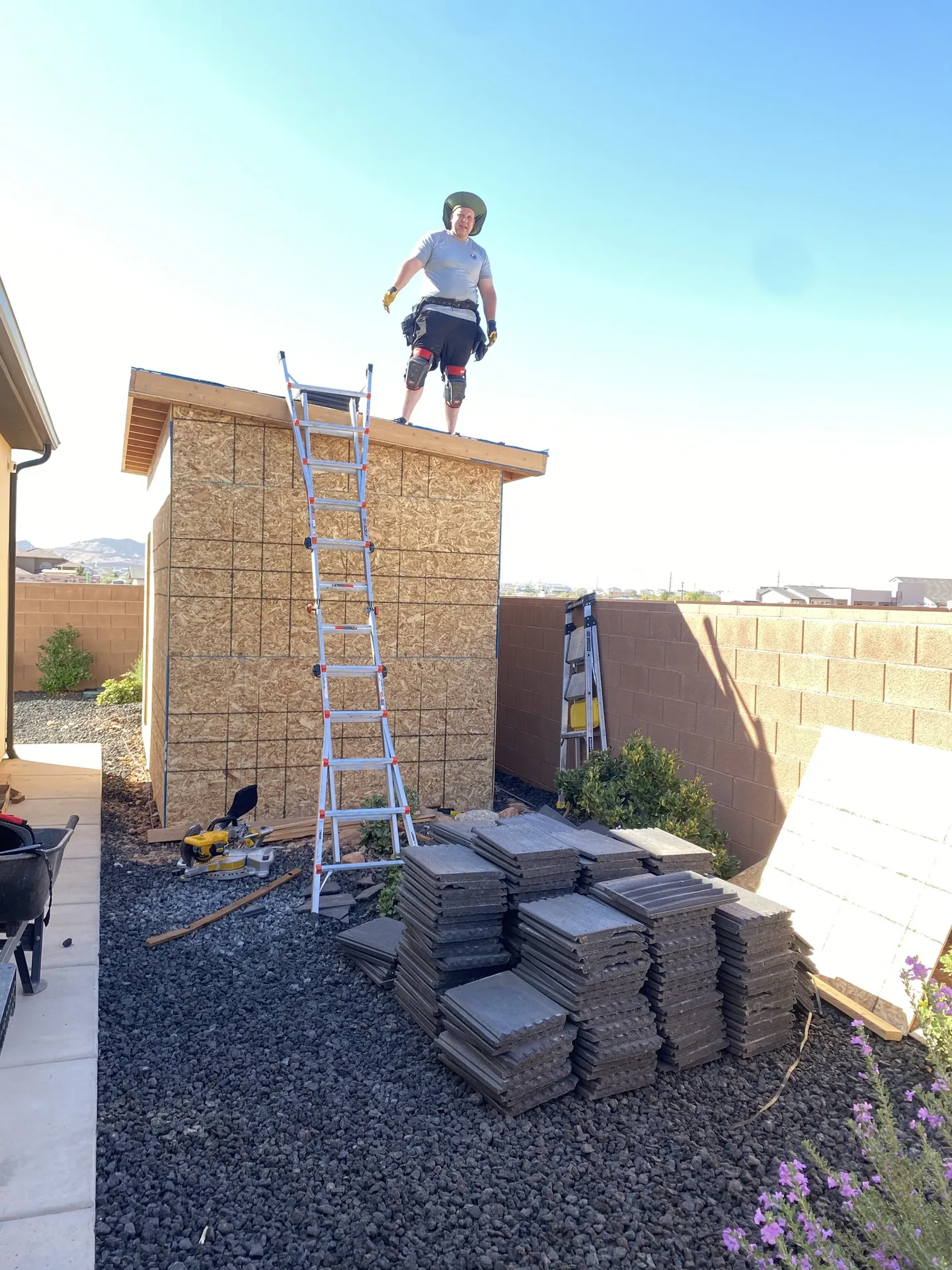 Crew member standing on the finished shed roof after sheathing and roofing