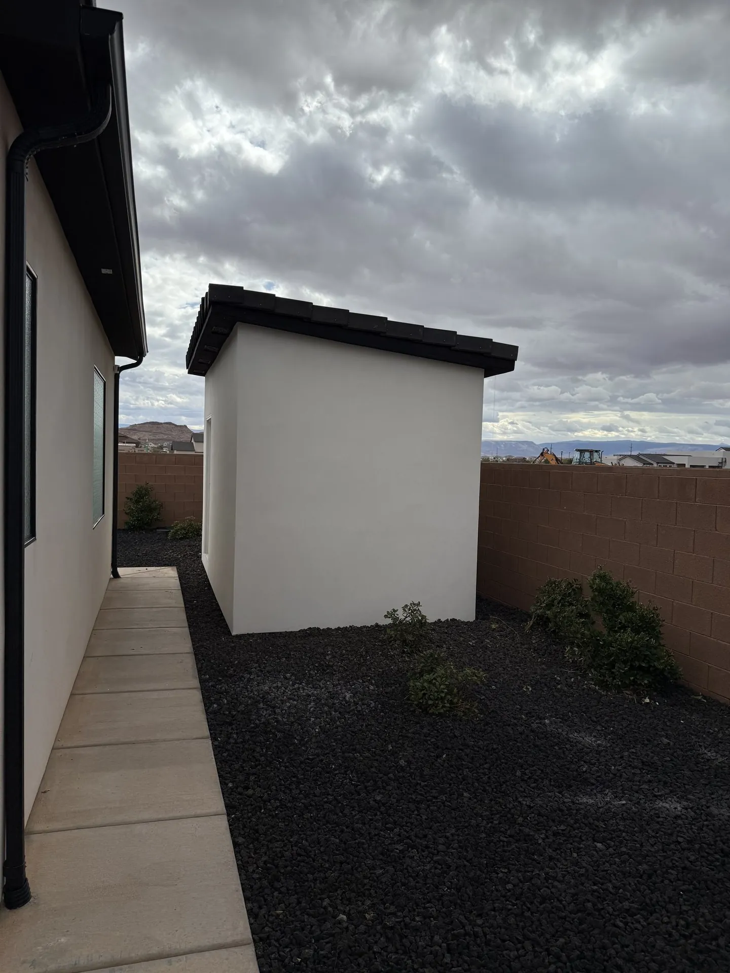 Side view of the finished stucco shed with mountains in the background
