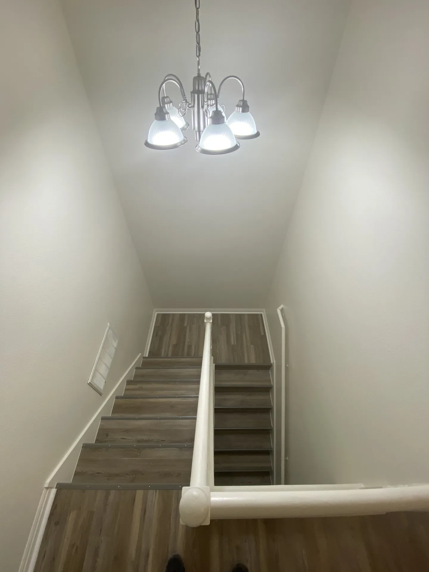 New chandelier hung in the apartment stairwell after the remodel