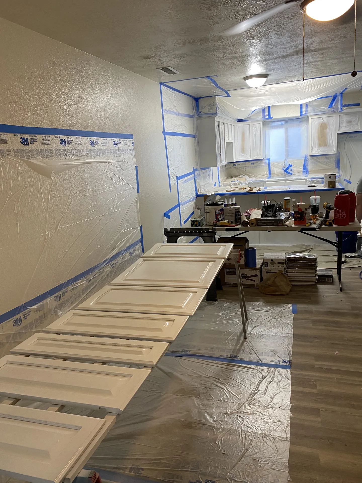 Cabinet doors removed and freshly spray-painted gray, drying flat
