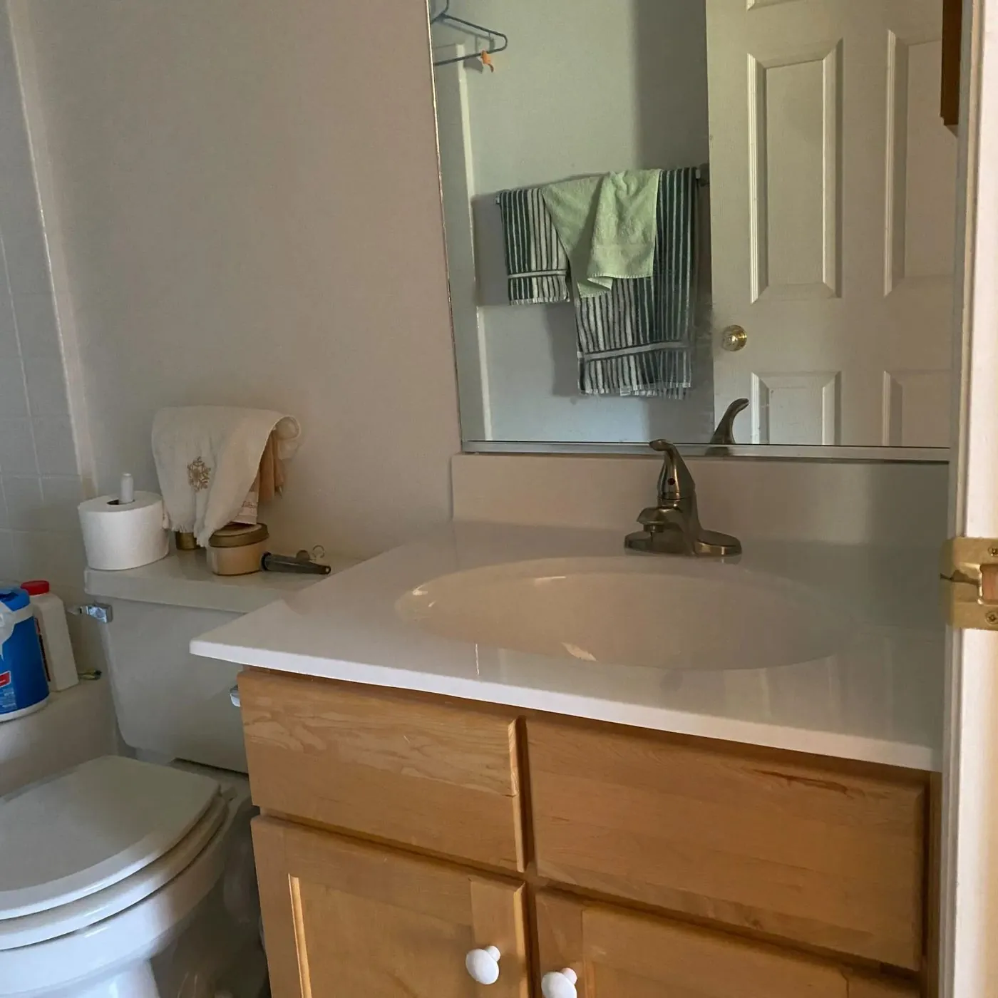 Bathroom vanity after faucet replacement — new white countertop with brushed nickel single-handle faucet installed