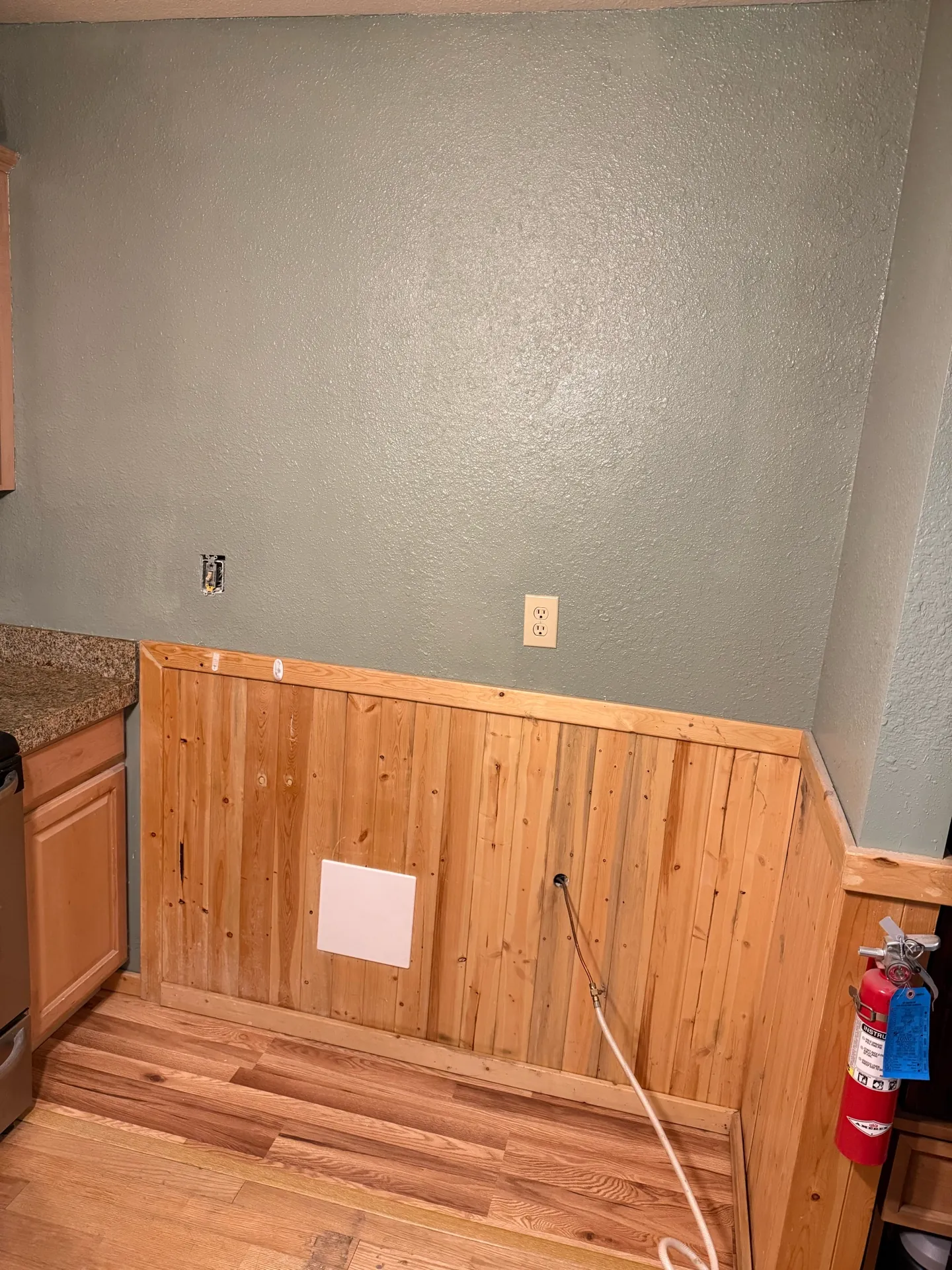 Damaged drywall section cut back to clean framing during the kitchen wall repair