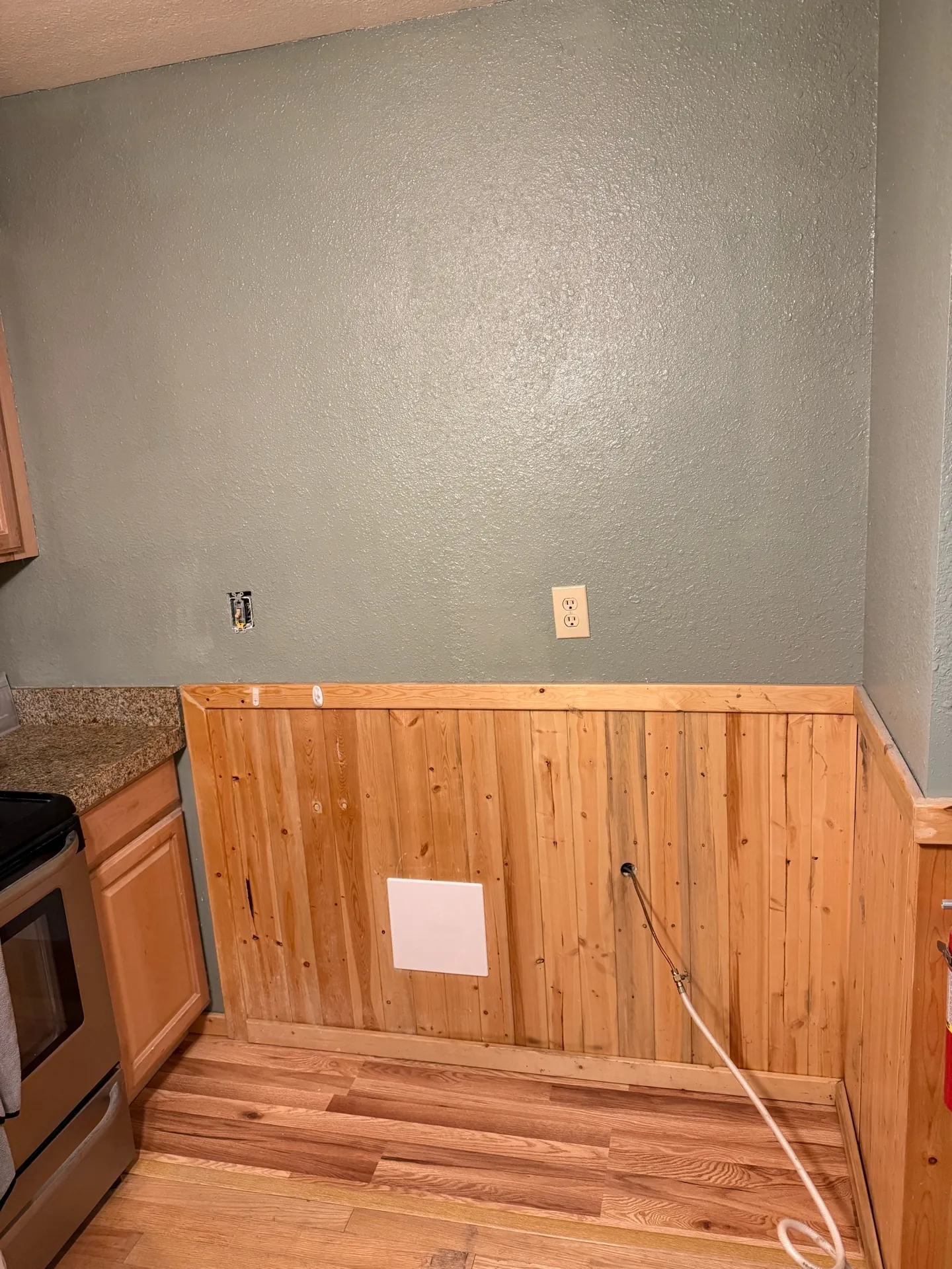 New drywall hung and taped over the repaired kitchen wall section