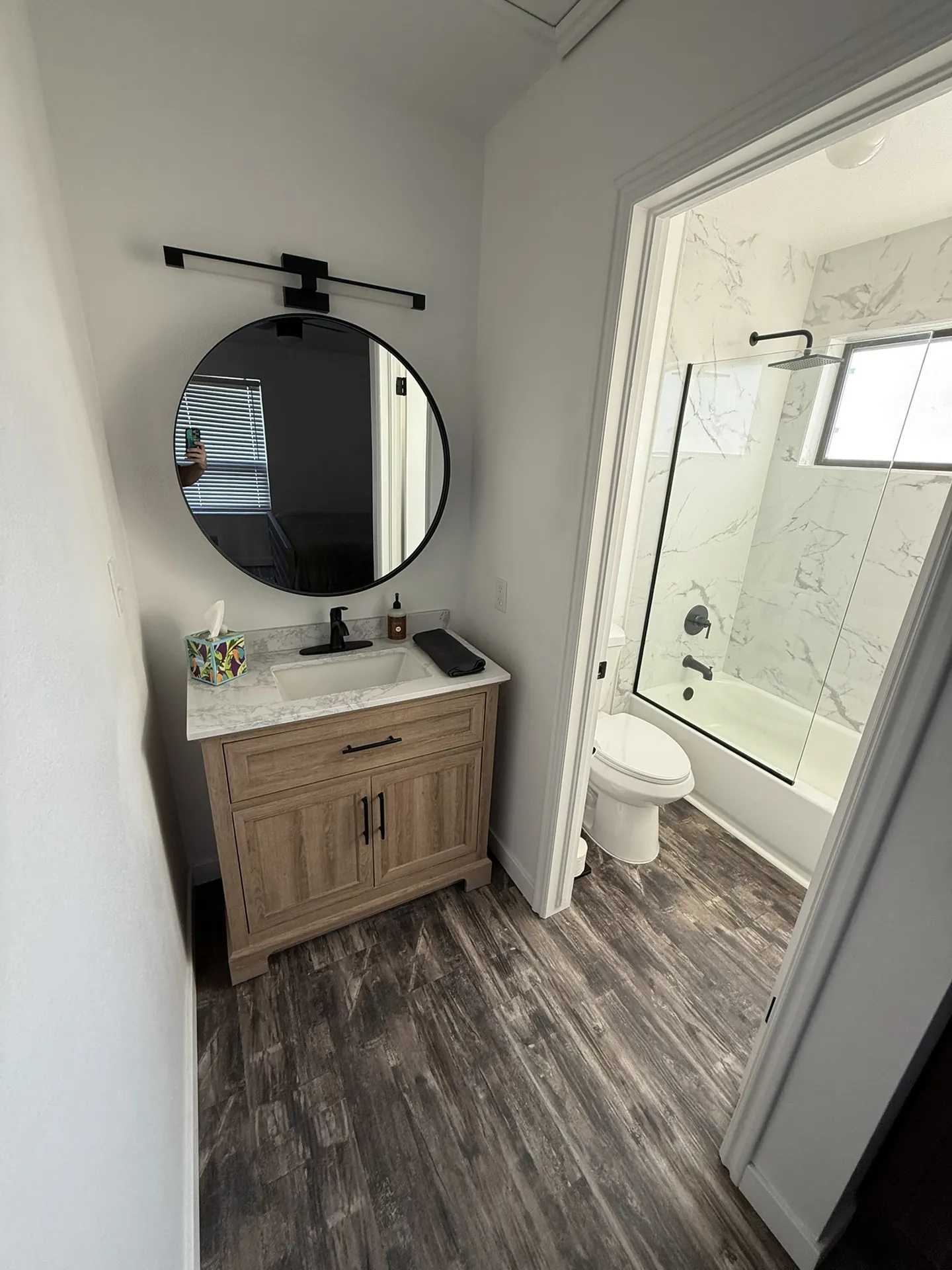 Remodeled hall bathroom vanity with new counter, mirror, and lighting