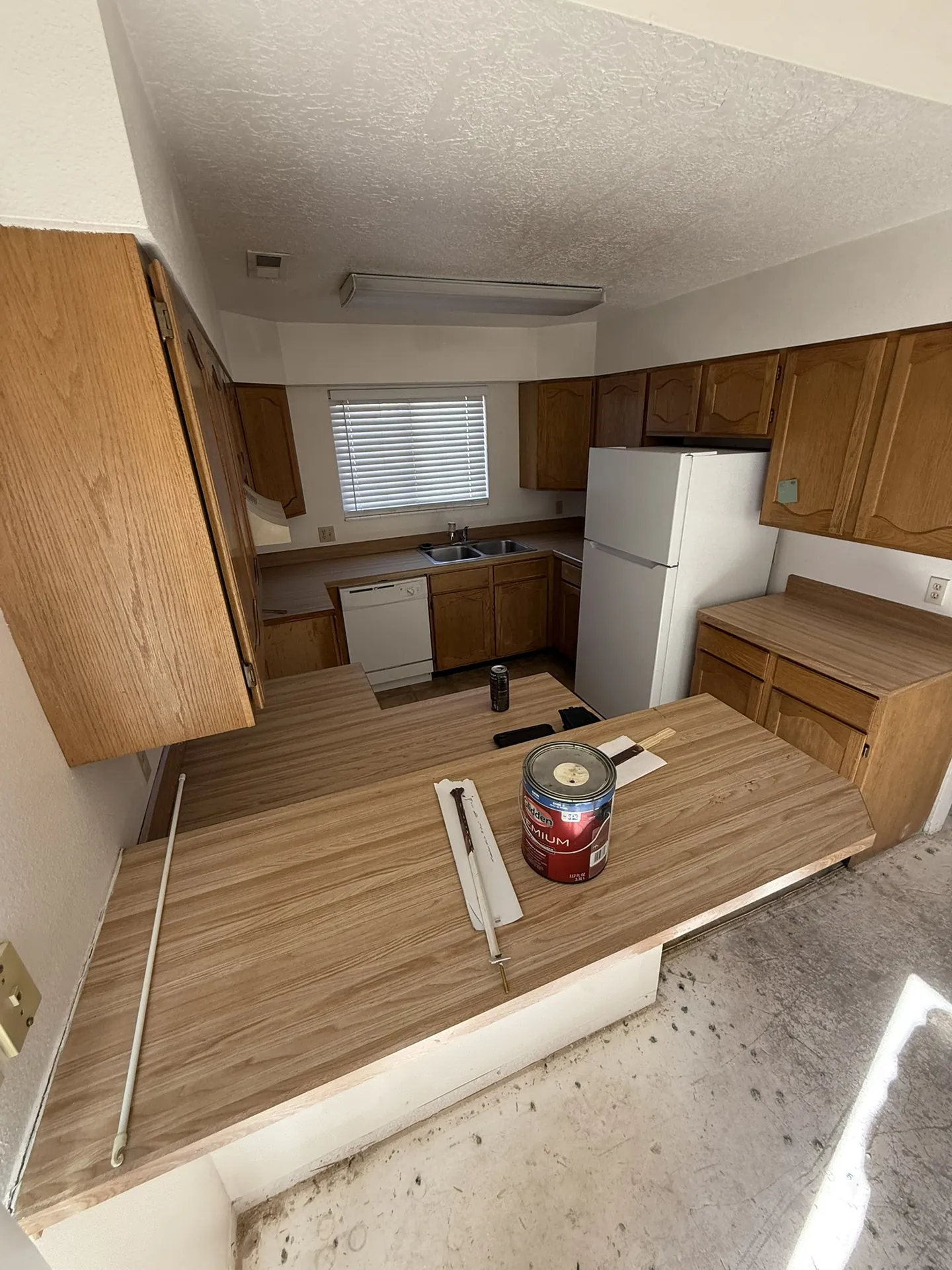Original condo kitchen with honey oak cabinets and dated finishes before the remodel