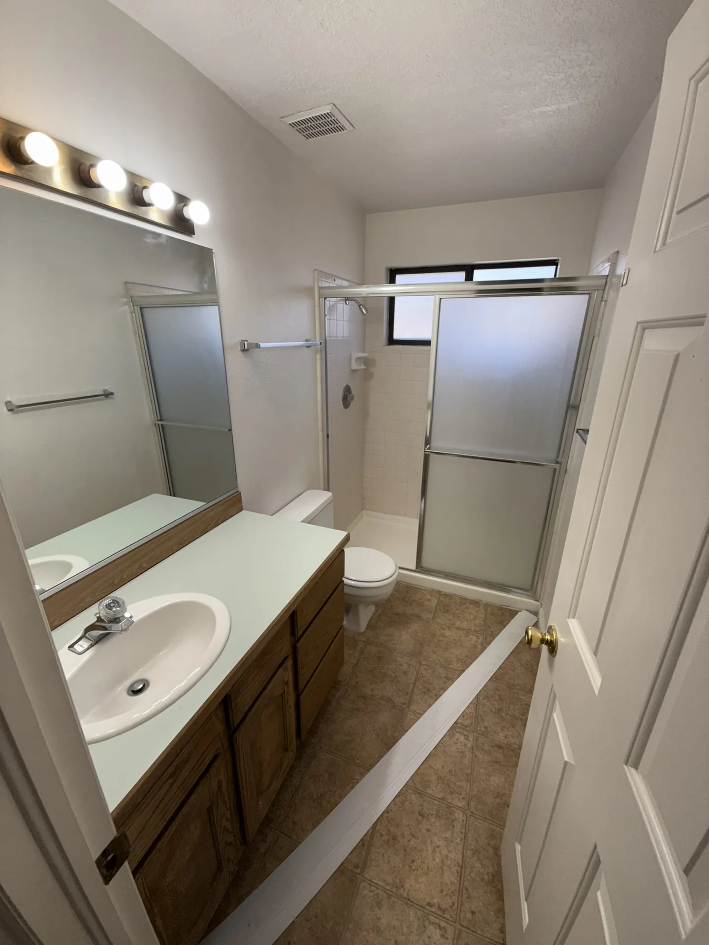 Master bathroom before remodel with oak vanity and dated tile