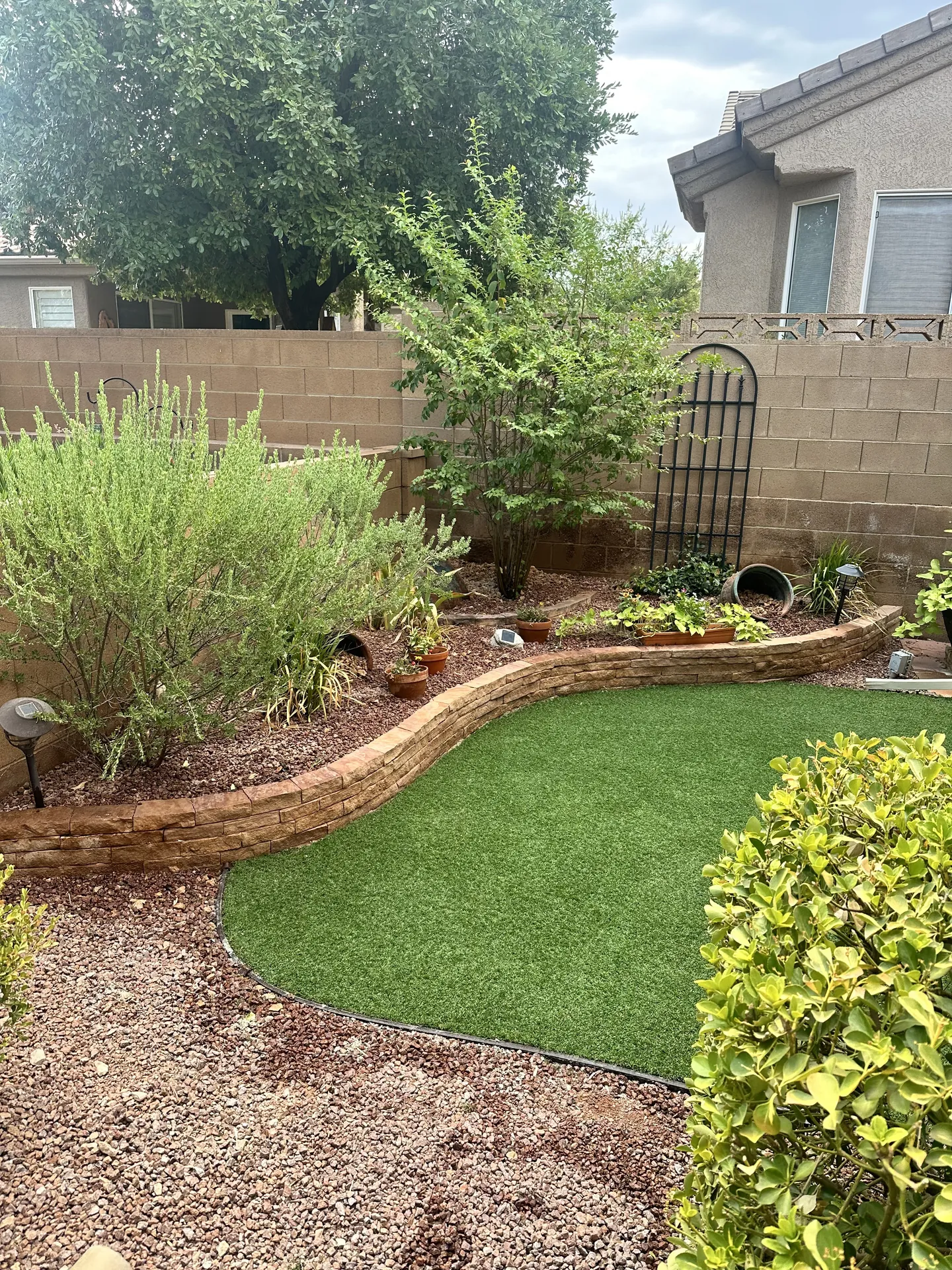 Clean turf edge following the curved retaining wall corner