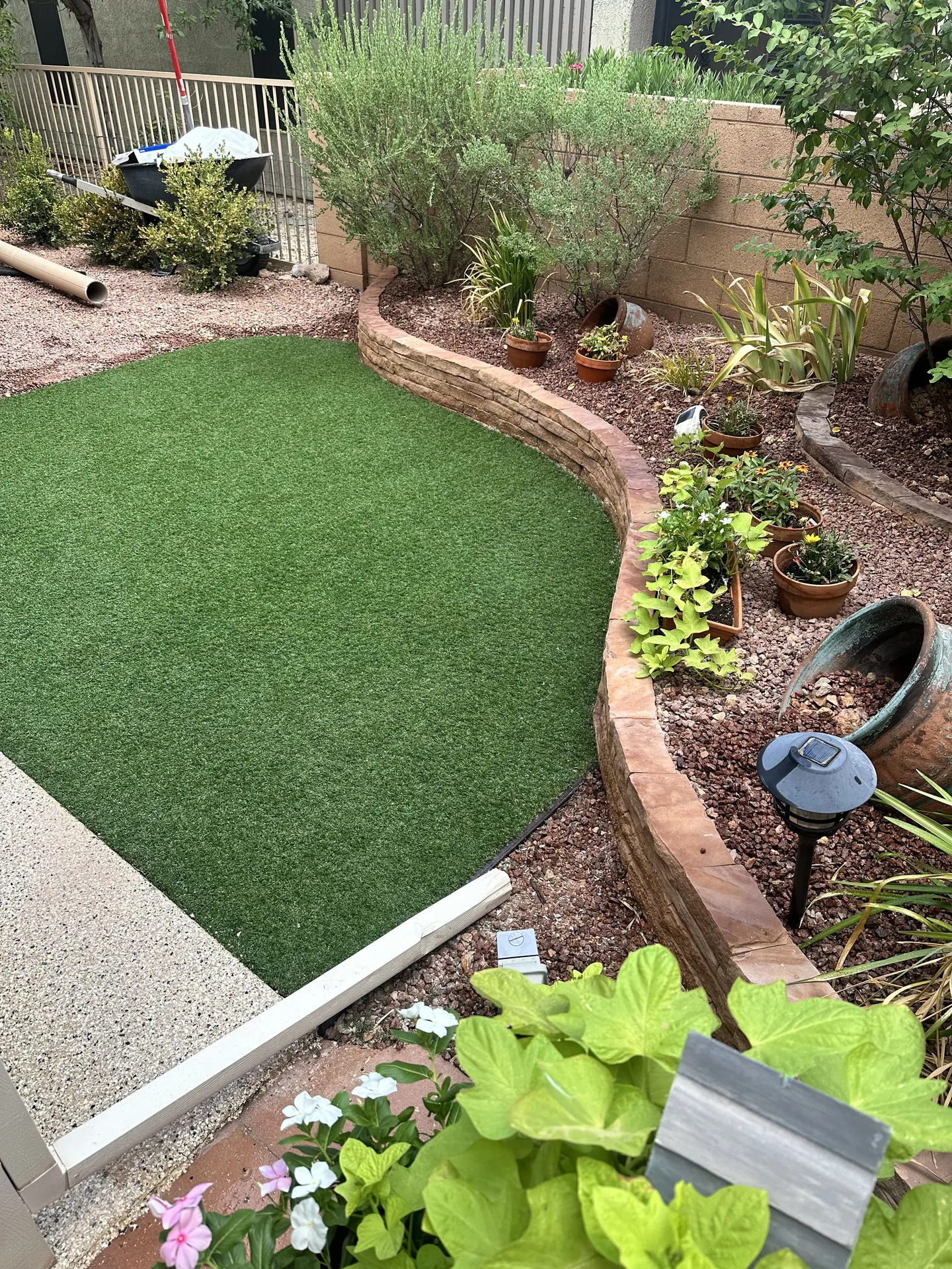 Crew laying and positioning the artificial turf over the prepared base
